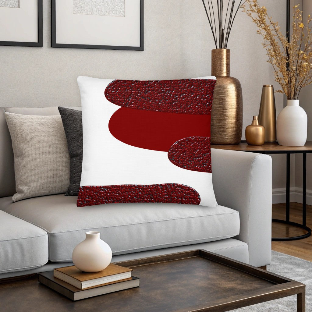 Decorative white pillow with red abstract design on a gray sofa in a living room setting. Scandinavian design pillow